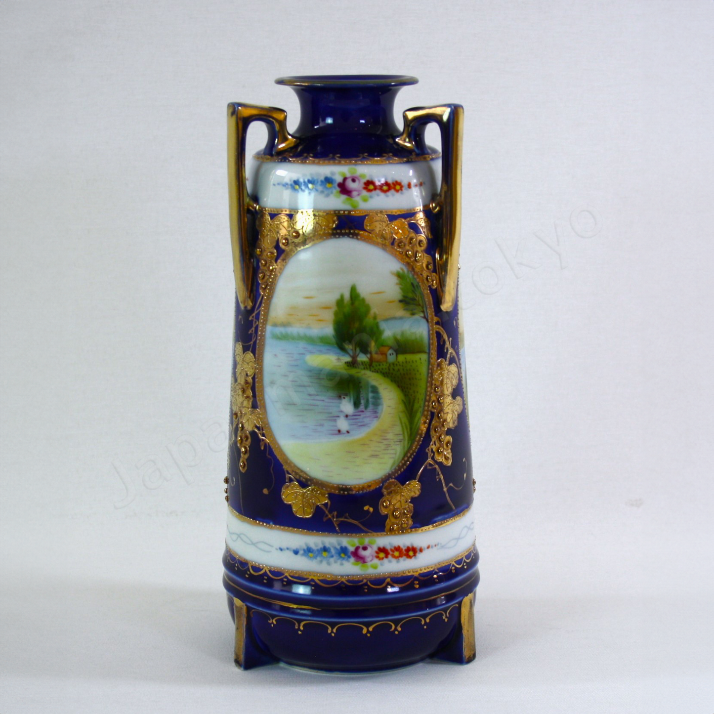 Front view:Japanese antique fine china. Old Noritake.
Vase with handles
Lakeside landscape design
Polychrome, gold and cobalt blue