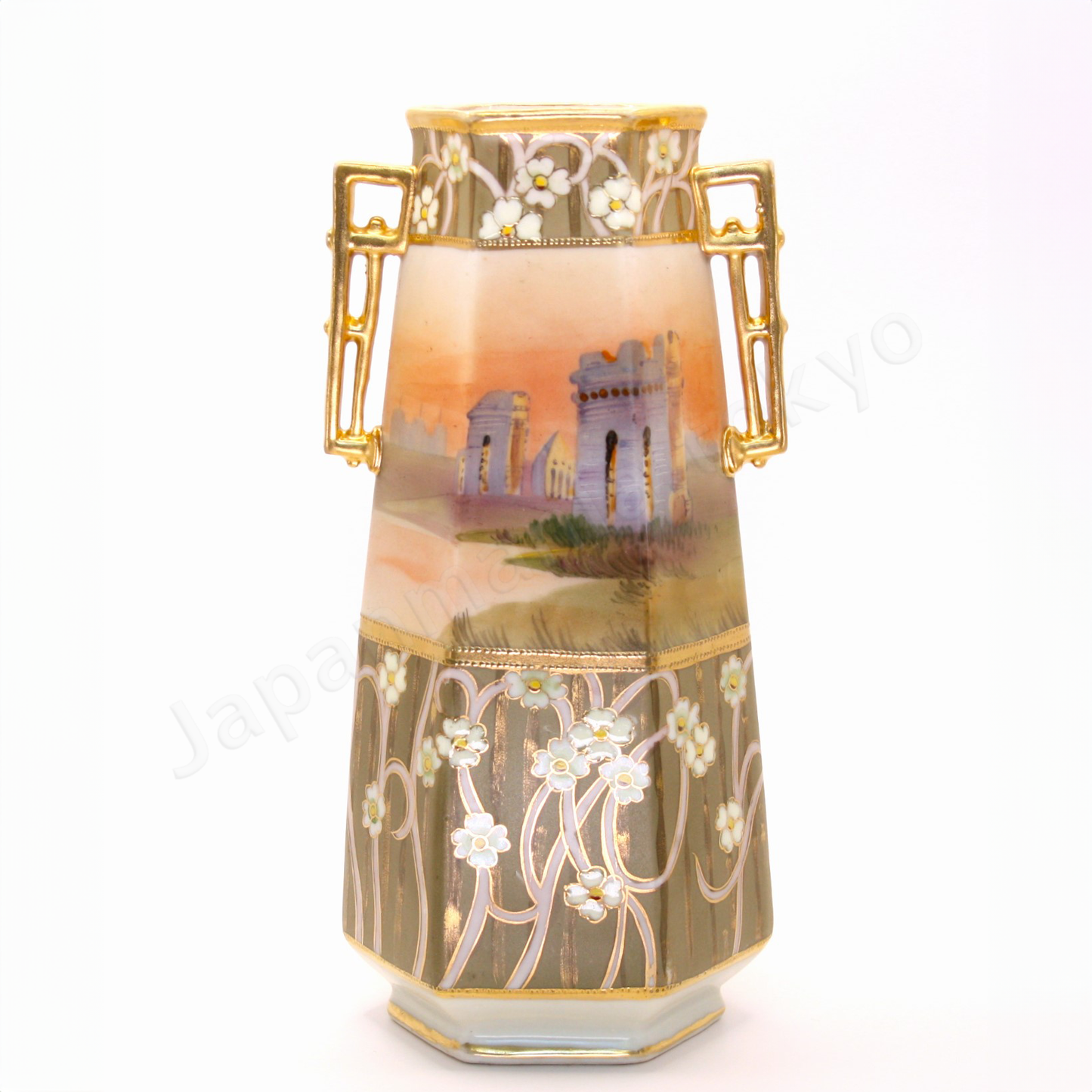 Front view: Japanese antique fine china. Old Noritake, featuring castle ruins framed within floral motifs and bordered with gold accents on the top, bottom, and handles.