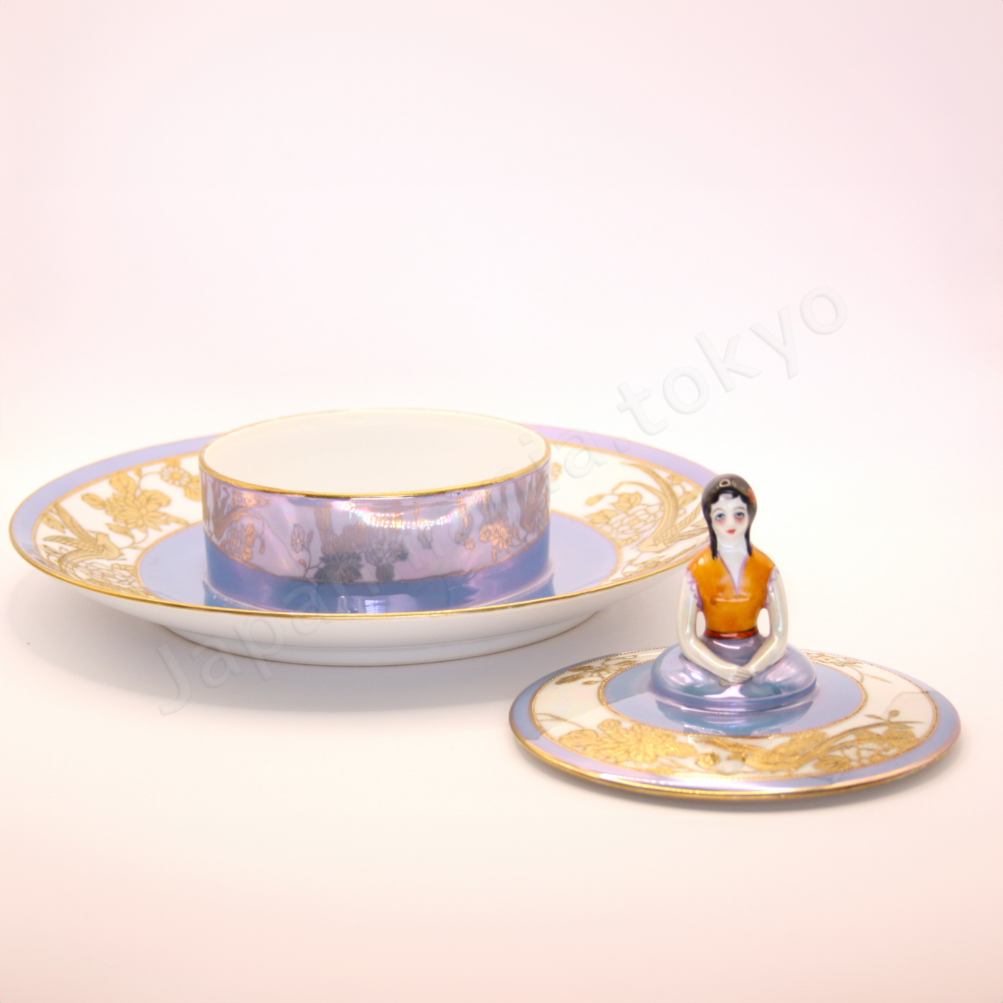 Front view: Japanese antique fine china. Old Noritake, Dip Dish, showcasing its unique Art Deco style and a lady-shaped lid with vibrant floral motifs and a beautiful polychrome luster finish.